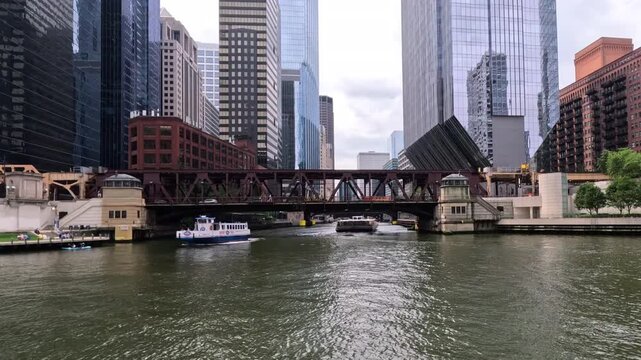 Boats, trains, cars, kayaks and people make for a busy day on the Chicago River in Chicago, Illinois. Majestic views of iconic Chicago, Illinois urban architecture in the Fulton River District.