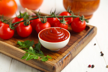 Bowl with tasty ketchup and ingredients on white wooden background, closeup