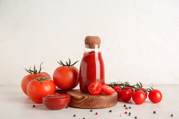 Bowl and bottle with tasty ketchup on white grunge background