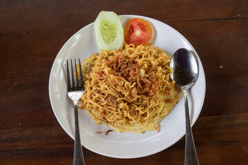 Fried noodles with garnished veggies and crispy toppings. Asian noodle dish served with fresh sides. meal with fresh garnishes. Traditional fried noodles with toppings. Quick, tasty fried noodle dish
