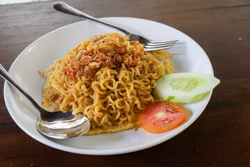 Delicious fried noodles with fresh veggies. Quick fried noodles served with cucumber and tomato. Easy meal: Fried noodles topped with crispy onions. Simple fried noodles with a fresh twist