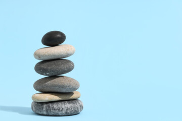 Stack of pebbles on blue background. Zen concept