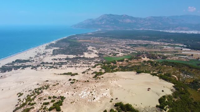 aerial drone footage capturing the vast Patara Sand Dunes and the expansive Patara Beach along the beautiful Mediterranean coastline of Turkey. This footage showcases the unique natural landscape, whe