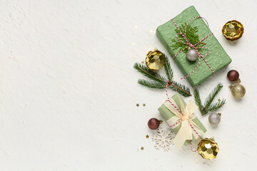 Composition with gift boxes, Christmas balls and fir tree branches on white grunge background