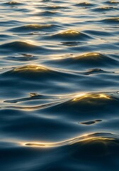 Serene seascape with undulating waves and shimmering golden sunlight reflections on the surface of the dark blue sea