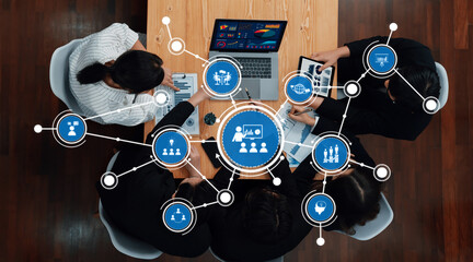 Collaborative Business Meeting with Diverse Team Analyzing Data on Laptops and Tablets Around Wooden Table in Modern Office Setting. Amity