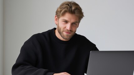 Smiling man working on laptop in modern workspace with relaxed atmosphere
