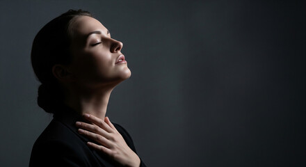 A serene and dramatic portrait of a woman with her eyes closed, basking in a soft light, a perfect concept for peace, mindfulness, and inner calm