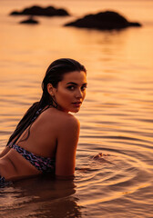 Woman in Bikini Lying in Shallow Water Looking Back at Dusk Serene Ocean Sunset Mood