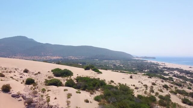 aerial drone footage capturing the vast golden sand dunes of Patara, Turkey, leading down to the pristine Mediterranean coastline. This scenic landscape showcases the unique natural beauty of the Pata