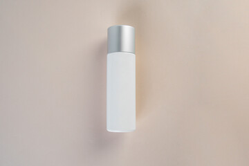 Cosmetic product in tube, bottle, lotion or serum with stylish props on light brown background. 