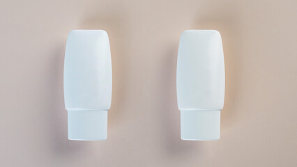 Cosmetic product in tube, bottle, lotion or serum with stylish props on light brown background. 