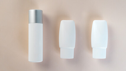 Cosmetic product in tube, bottle, lotion or serum with stylish props on light brown background. 