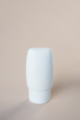 Cosmetic product in tube, bottle, lotion or serum with stylish props on light brown background. 