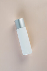 Cosmetic product in tube, bottle, lotion or serum with stylish props on light brown background. 
