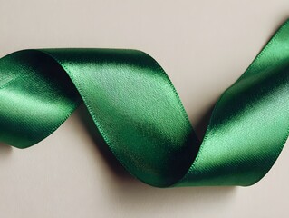 Close up photo of a green ribbon with plain color background