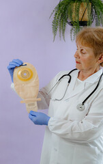 An elderly doctor in a white coat holds a colostomy bag.