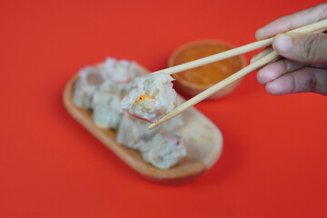 Dim Sum with Sauce on Red Background