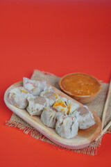 Dim Sum with Sauce on Red Background