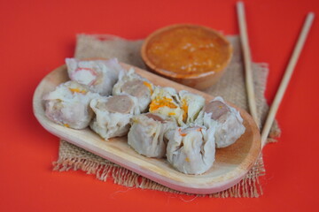 Dim Sum with Sauce on Red Background