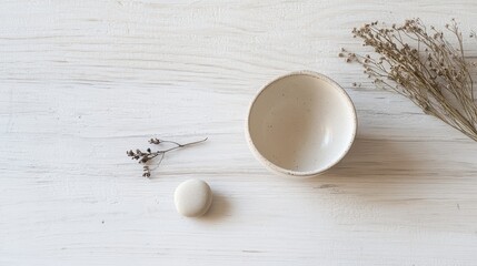 A white bowl with a small flower and a small white bowl