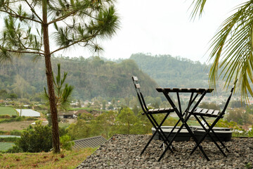Relaxing spot with black chairs and table surrounded by nature