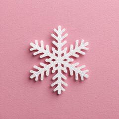A white snowflake decoration rests on a soft pink background