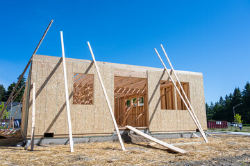 New housing development construction project, framing stage, wood wall studs and Oriented Strand...