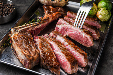 잘려있는 스테이크를 포크로 들어올리다