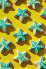 Obraz premium Star-shaped cookies, teal icing, yellow background