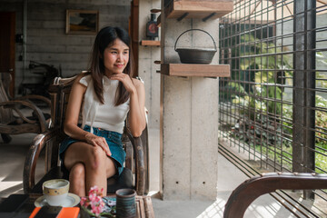 A woman enjoys a peaceful moment in a stylish cafe, surrounded by natural light and modern decor.