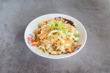 Thai glass noodle stir-fry with vegetables (Pad Woon Sen), enamel bowl on grey stone