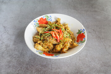 Spicy dry curry pork with herbs (Thai southern style) in enamel bowl