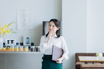 飲食店で悩む若い女性のスタッフ
