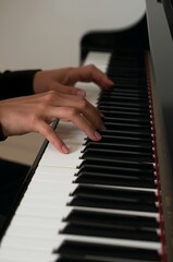 Fototapeta premium Melody in Motion: Hands gracefully dance across the piano keys, weaving a tapestry of sound and emotion in a moment of musical passion.