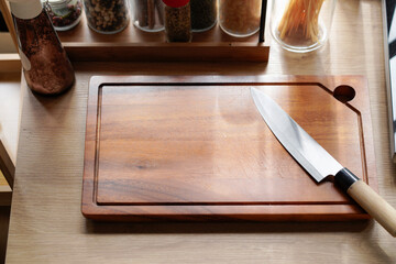 Wooden cutting board with a knife blade deeply inserted warm kitchen scene