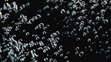 A captivating close-up of bubbles rising in liquid, set against a dark background, showcasing their intricate shapes and formations.
