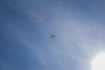Passenger Airplane Flying in Blue Sky Near Sun
