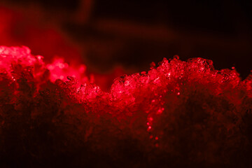 Mysterious abstract red light glowing from crystal texture. macro detail shot showing intense energy on dark black background. luminous substance creates powerful feel