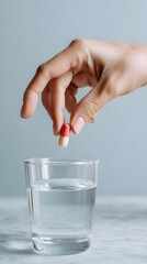 Hand Taking a Capsule with Water Vertical Photo