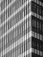 Obraz premium A close-up view of a contemporary high-rise building facade highlighting the geometric patterns created by its windows and structural elements.