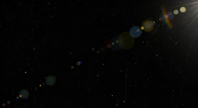 Abstract dark background with bright lens flare effect and dust particles