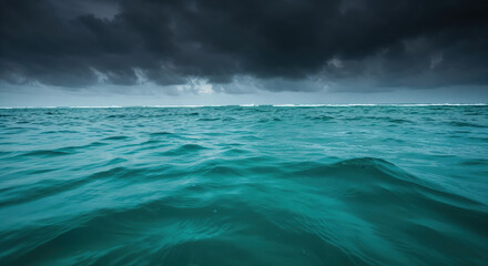 Ocean's Murmur Under Stormy Skies: Capturing the untamed beauty of the sea, the photograph unveils a tranquil turquoise expanse crowned by a tempestuous sky.