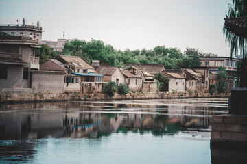 A tranquil scene near The Palace Museum in Beijing, featuring traditional architecture reflected in...
