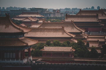 An aerial view of The Palace Museum in Beijing. The image showcases numerous traditional rooftops,...