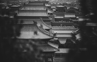 Aerial view of The Palace Museum, Beijing, showcasing historic rooftops. The monochrome tones...