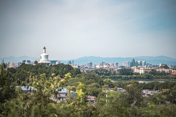 A scenic view of Beijing, showcasing The Palace Museum from a high vantage point. Lush greenery...