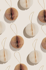 Stylish pattern of Paper Christmas Ornaments, hanging ivory beige and brown New Year decorations as round balls, sunlight shadow, minimal aesthetic holiday flat lay, festive top view repeat photo