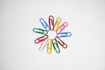 A group of colorful paper clips arranged in a circular pattern on a clean white background. This image is perfect for concepts of teamwork, organization, creativity, and connection.

