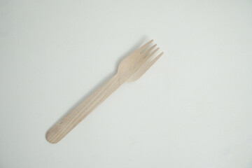 A single, eco-friendly wooden fork rests on a clean white background. This image is perfect for concepts of sustainability, zero-waste, and environmentally conscious dining.

